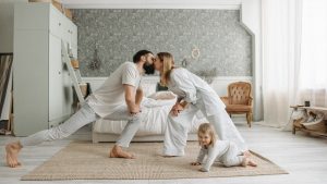 A family enjoying playful bonding moments in a stylish, minimalistic bedroom setting.